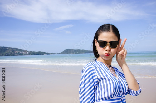 Beautiful Asia woman on beach with blue sky. © Prapan