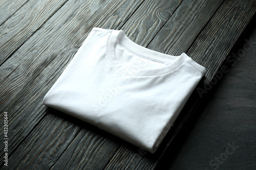 White sweatshirt on wooden background, space for text