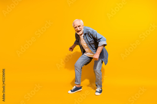 Full length body size of cool grandfather dancing feeling young wearing stylish outfit isolated on vivid yellow color background