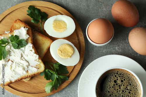 Concept of tasty breakfast with boiled eggs on gray textured table