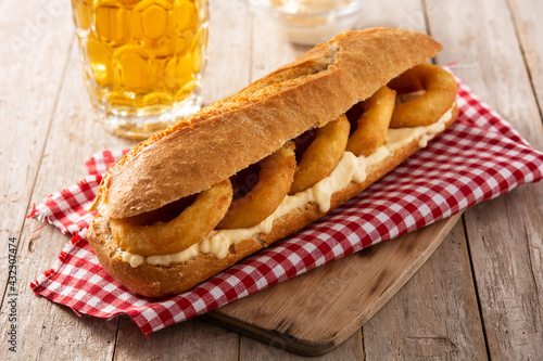 Calamari rings sandwich with beer on wooden table. Typica spanish food	 photo