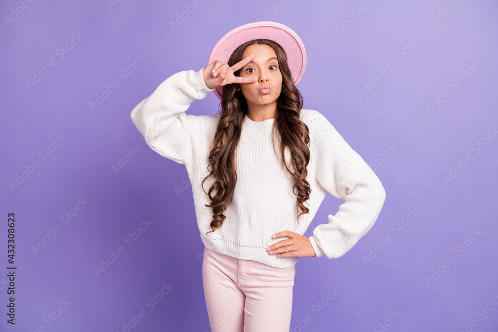 Photo of brunette long hairdo sweet girl blow kiss show v-sign wear cap sweater trousers isolated on violet color background Photo of brunette long hairdo sweet girl blow kiss show v-sign wear cap sweater trousers isolated on violet color background