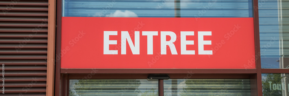 Red and white french entrance sign at the front of a building