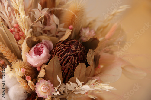 Bouquet of dry flowers and leaves on blurred background, closeup