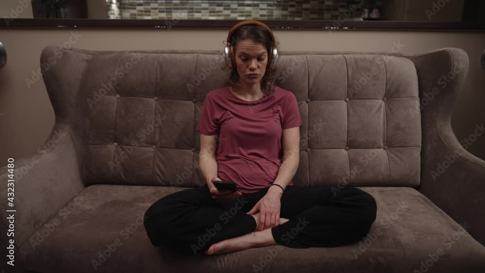young woman with wireless headphones on her head on the couch young woman with wireless headphones on her head on the couch