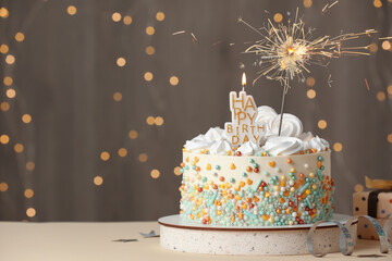 Beautiful birthday cake with festive decor on white table. Space for text
