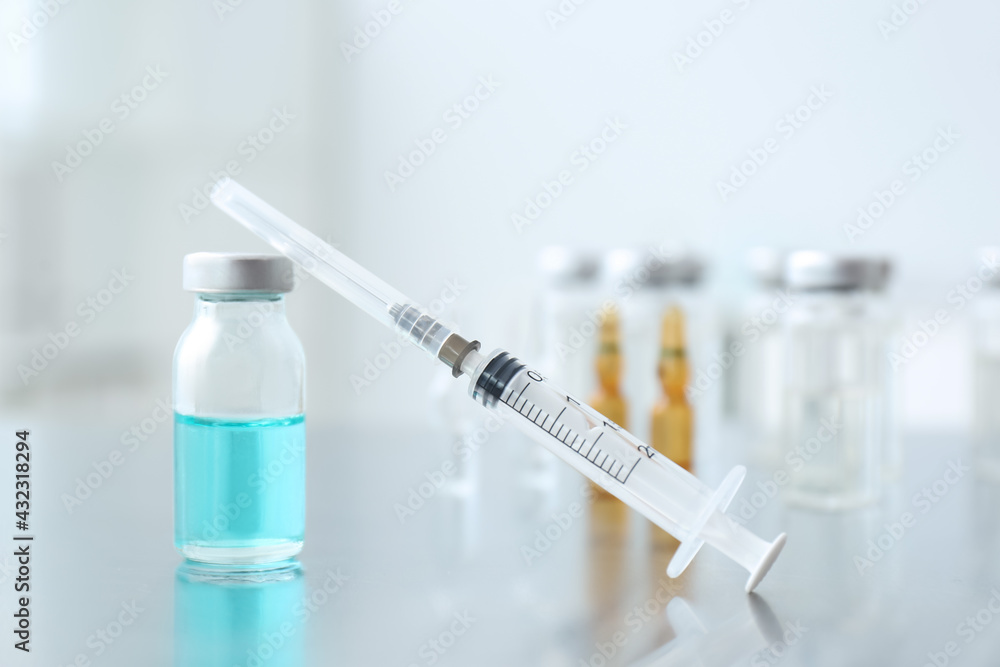 Syringe with vial of medicine on table Syringe with vial of medicine on table