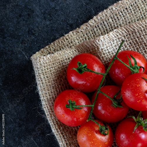 Pomodorini rossi su sacco juta con sfondo in texture