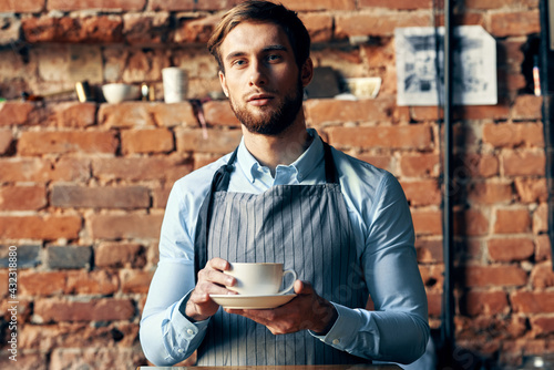 man in apron barista work professional a cup of coffee in hand