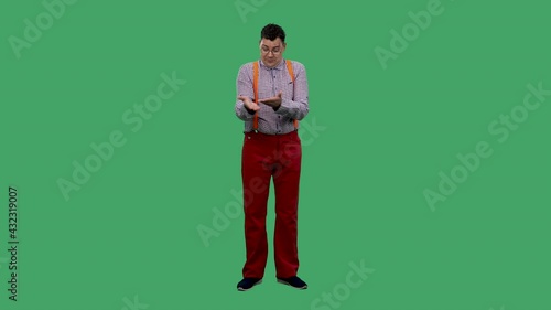 A portrait of a man who talks about something, points at something with his hands, justifies himself, shrugs his shoulders. A man in glasses in the studio on a green screen. Slow motion. photo