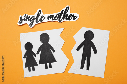 Being single mother after divorce concept. Paper cutouts demonstrating broken family on orange background  flat lay