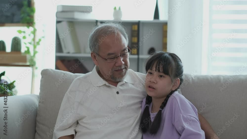 An Asian grandfather and grandson talking on sofa. They have a good rerationship. Senior elder asian family concept An Asian grandfather and grandson talking on sofa. They have a good rerationship. Senior elder asian family concept