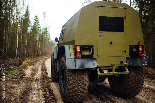 a four-wheel drive all-terrain vehicle drives through the forest through the mud. a passable SUV with large wheels and high clearance. special transport for foresters rides through swamps and mud photo