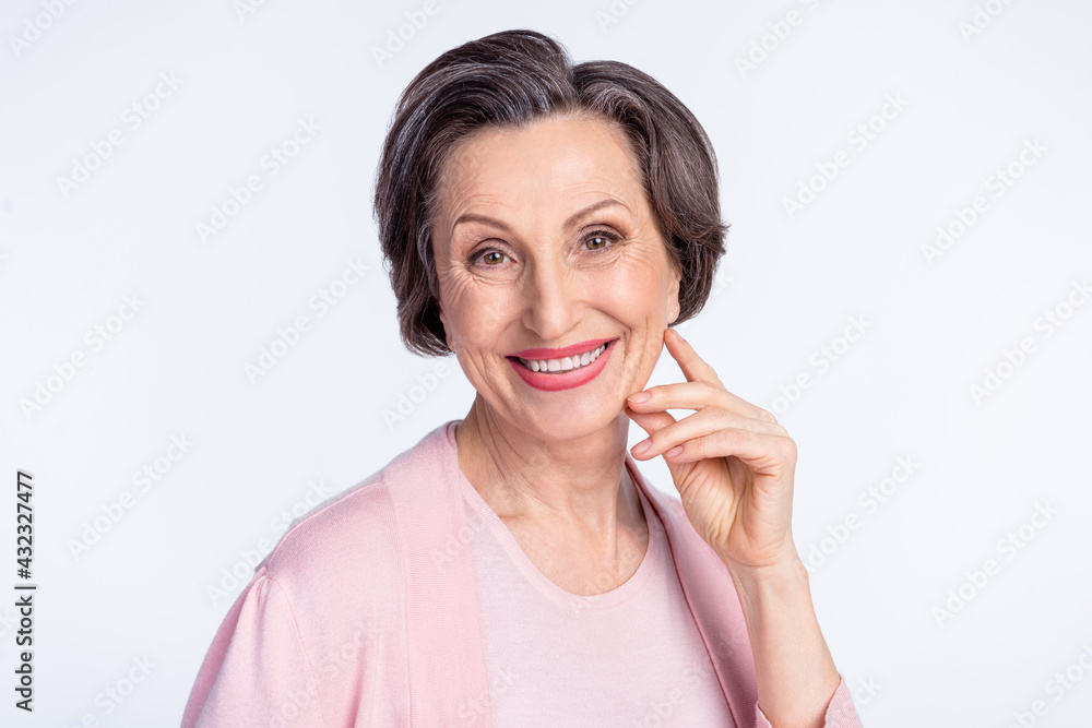Photo of elderly attractive woman happy positive toothy smile hand touch cheek isolated over grey color background Photo of elderly attractive woman happy positive toothy smile hand touch cheek isolated over grey color background