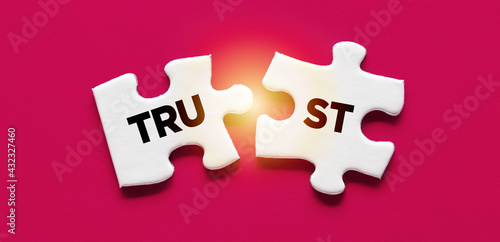 Fotografie Two puzzle pieces with the word Trust