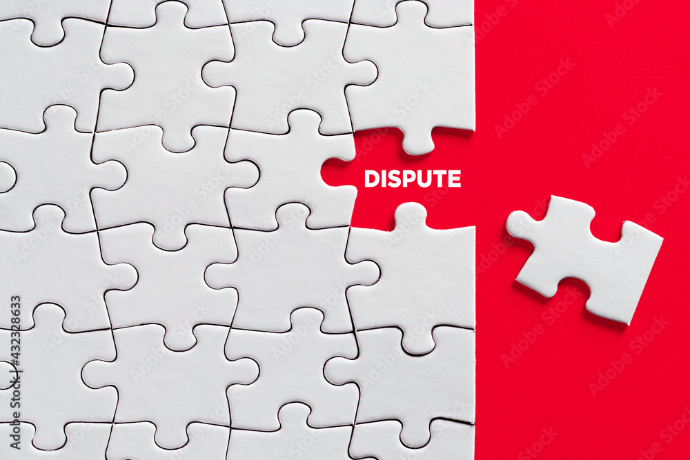 The word dispute written on missing puzzle piece on red background. Dispute resolution or to reveal a conflict The word dispute written on missing puzzle piece on red background. Dispute resolution or to reveal a conflict