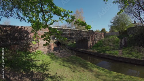 A man walking underneath a canal bridge in the UK photo