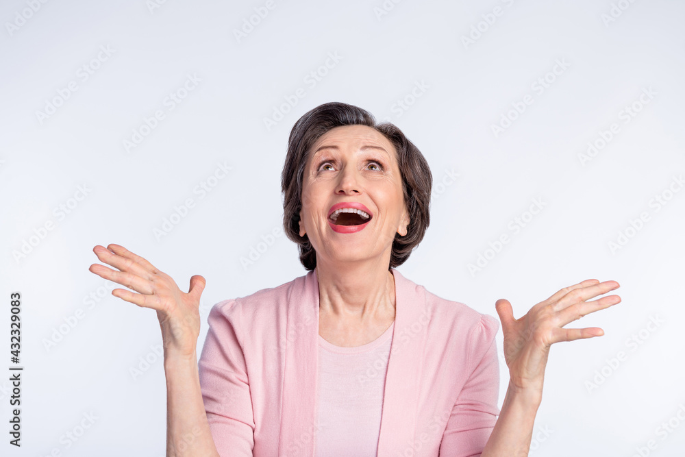 Photo of elderly excited woman happy positive smile amazed catch look empty space isolated over grey color background Photo of elderly excited woman happy positive smile amazed catch look empty space isolated over grey color background