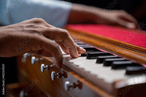 Close up of Hands playing Harmonium or reed organ an Indian classical music instrument. photo