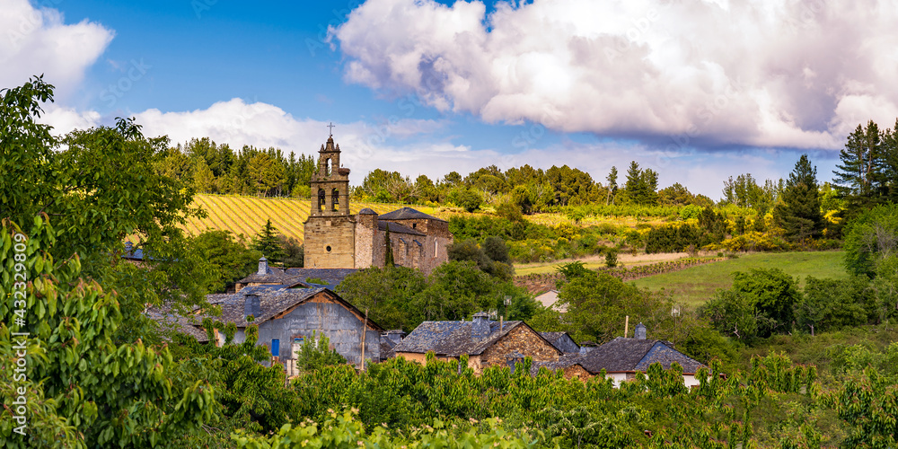 Panoramic view of the village of Arganza in the Bierzo region of northern Spain, with traditional slate roofs, stone built church tower and vineyard cultivation in the background..