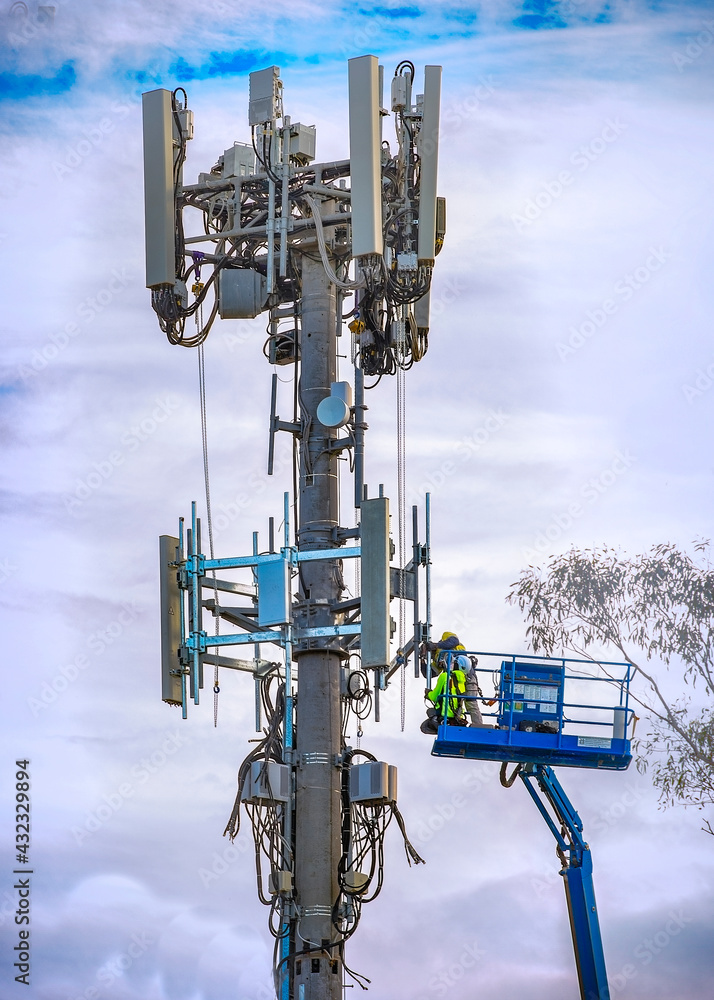 Worker technicians doing installation work on a mobile telecommunication cell tower for wireless internet connection in Australia Worker technicians doing installation work on a mobile telecommunication cell tower for wireless internet connection in Australia