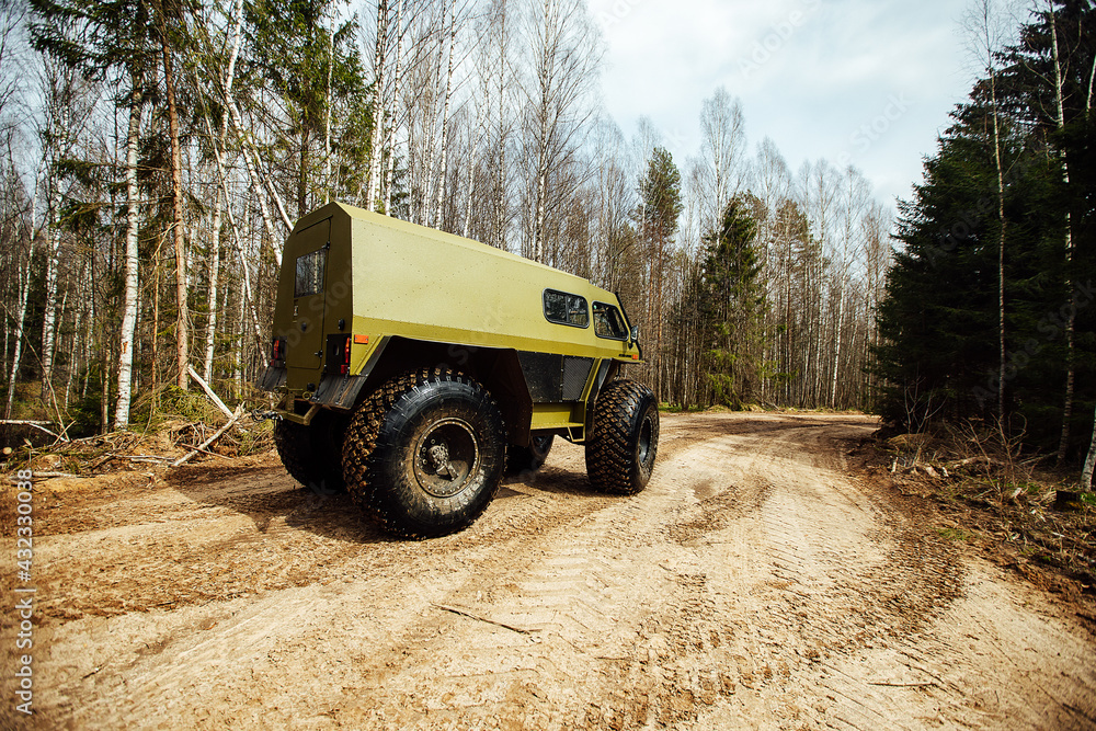 Obraz premium the all-terrain vehicle is driving through the swamp. an all-terrain vehicle in extreme wilderness conditions. high ground clearance of all-wheel drive industrial SUV