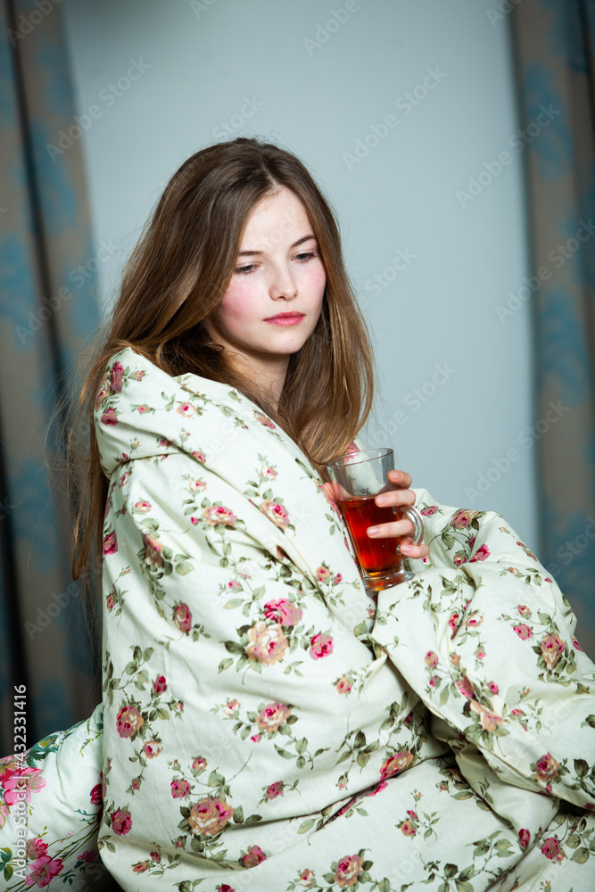 Young beautiful white woman awaking in light room. Relaxed woman lying in bed and drink tea. Good morning concept. Russian girl.
