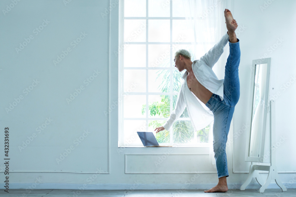 Handsome young male Ballet dancer practice in his room, while checking mail on laptop, social distance during quarantine lifestyle Handsome young male Ballet dancer practice in his room, while checking mail on laptop, social distance during quarantine lifestyle