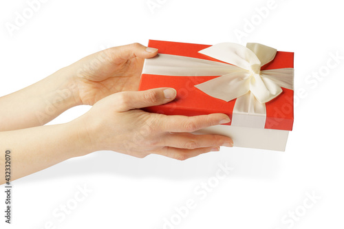 gift in hands isolated on white. female hands holding a red box with a white ribbon and a bow.