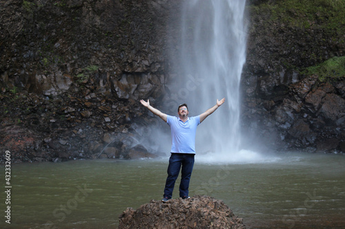 person in the waterfall thanking nature
