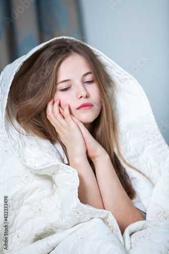 Happy girl waking up stretching arms on the bed in the morning. Beautiful young woman lying down in the bed and sleeping. white woman waking up