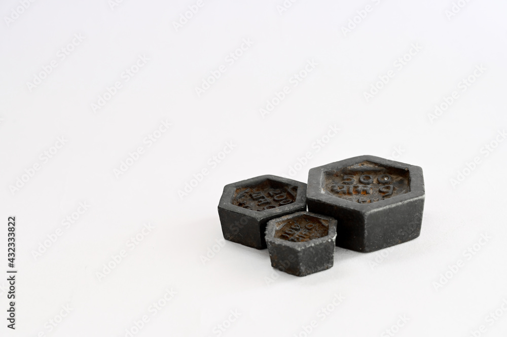 Black standard metric weights made of iron for weighing scales on white background Black standard metric weights made of iron for weighing scales on white background
