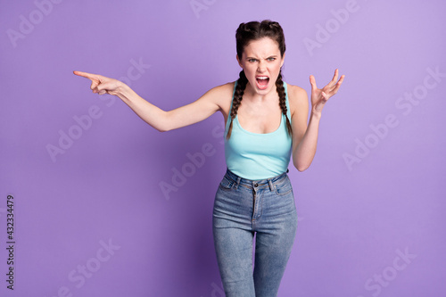 Portrait of mad furious crazy girl shouting loudly isolated over violet purple color background