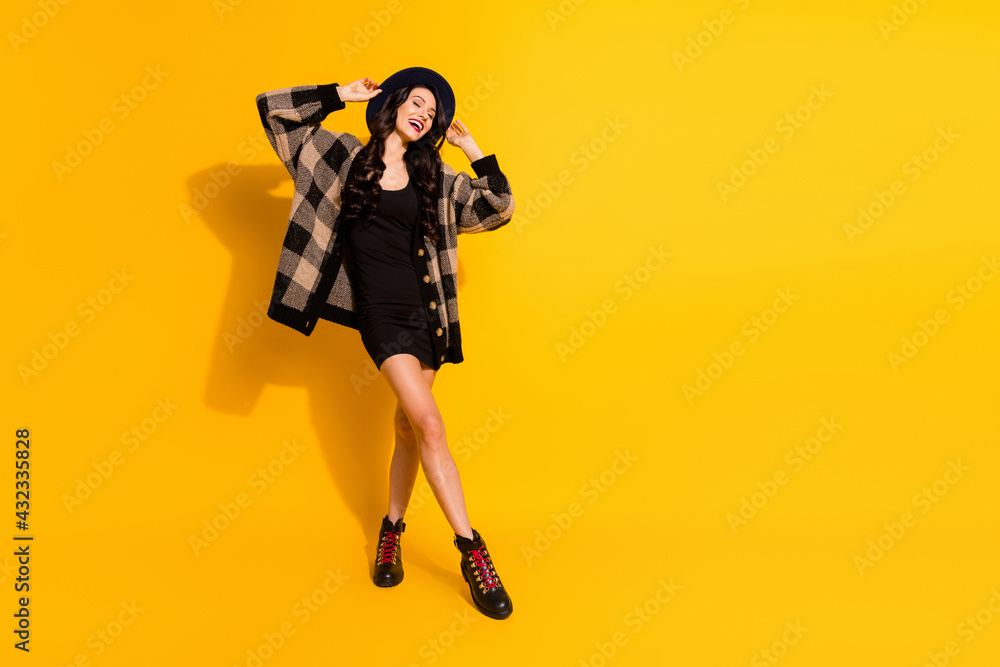 Full body photo of joyful relaxed young woman enjoy weekend wear black boots isolated on yellow color background