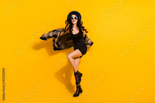 Full body photo of excited positive girl have fun partying toothy smile good mood isolated on yellow color background