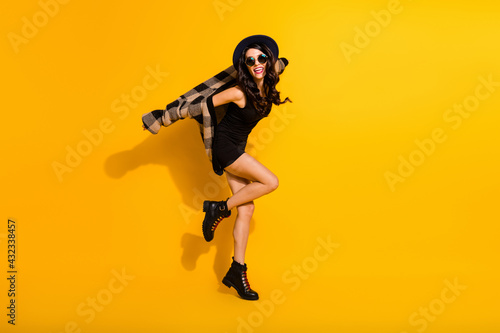 Full length profile portrait of carefree excited lady dancing beaming smile isolated on yellow color background