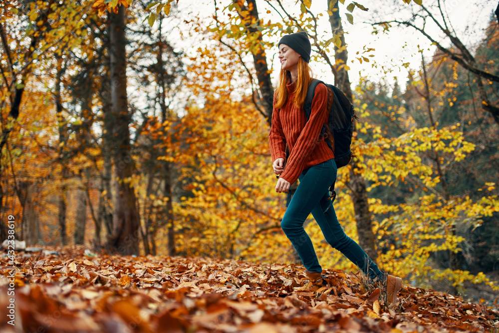 beautiful woman with a backpack in the park on nature landscape fallen leaves bottom view