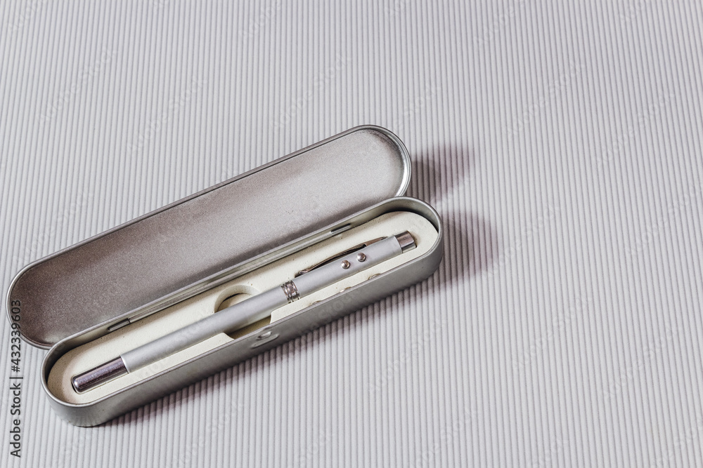 Laser pointer in the form of a telescopic stationery pen on a light background. Laser pointer in the form of a telescopic stationery pen on a light background.