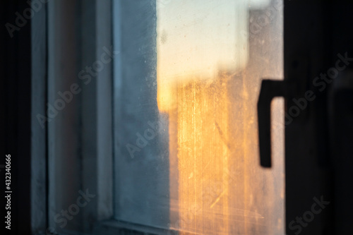 Artistic abstract photography for background. View from the window with dirty glasses to the setting sun. © Yura Tura