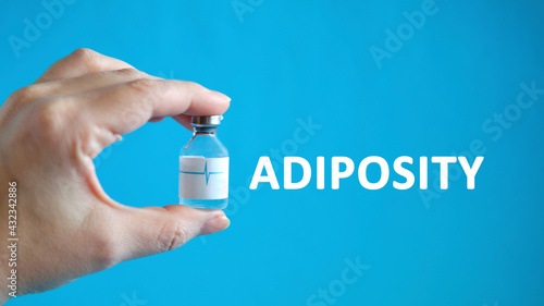 Adiposity text in the hand of a man holding a vial with a cure for healing photo