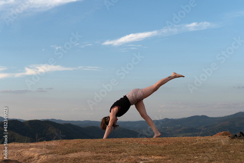 girl stretching alone on a sunny day with a big blue sky