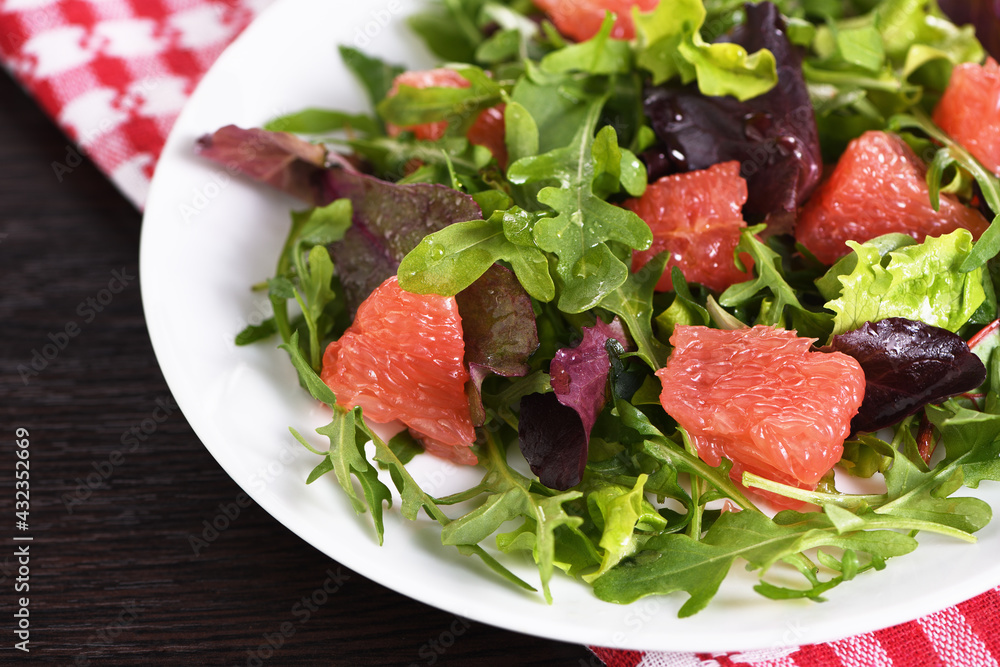Grapefruit salad, a mix of lettuce, arugula and olive dressing. Dietary menu. Proper nutrition. Vegetarian food.