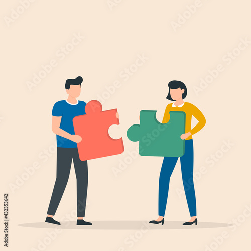 Man and woman with puzzle pieces working together. Teamwork concept.