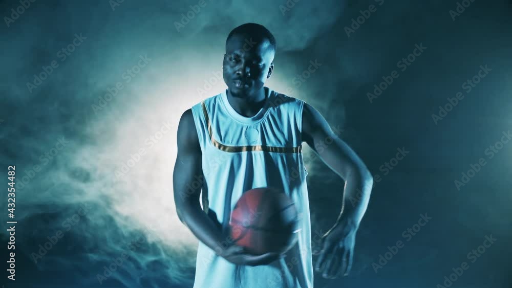 Dark room with smoke and an african basketball player Dark room with smoke and an african basketball player