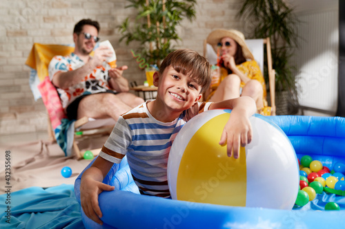 Portrait of relaxed boy in an inflatable ball pool at home © gpointstudio