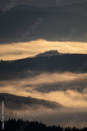 Beautiful sunrise over hills and countryside. Misty morning landscape with dramatic sky © AlexandruPh