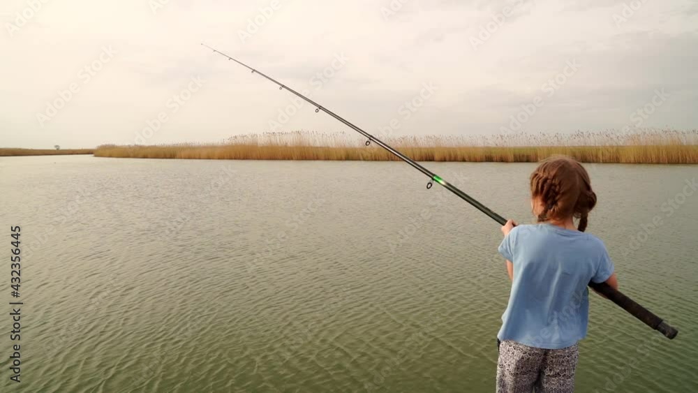 A small fisherman with a long fishing rod catches fish from the river. A small fisherman with a long fishing rod catches fish from the river.