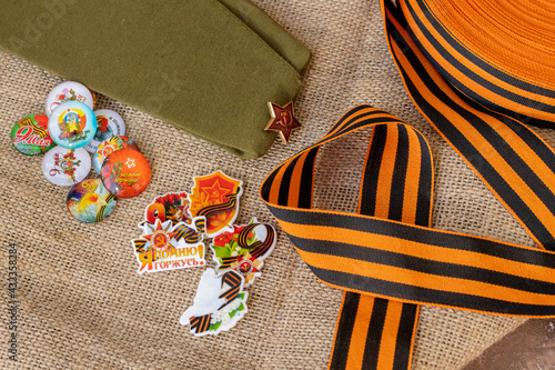 Concept background of May 9 russian holiday Victory Day. Red carnations, St. George's ribbon and order of the Red Star. Cabochons with the text in Russian: May 9, Victory, I remember, I am proud. On