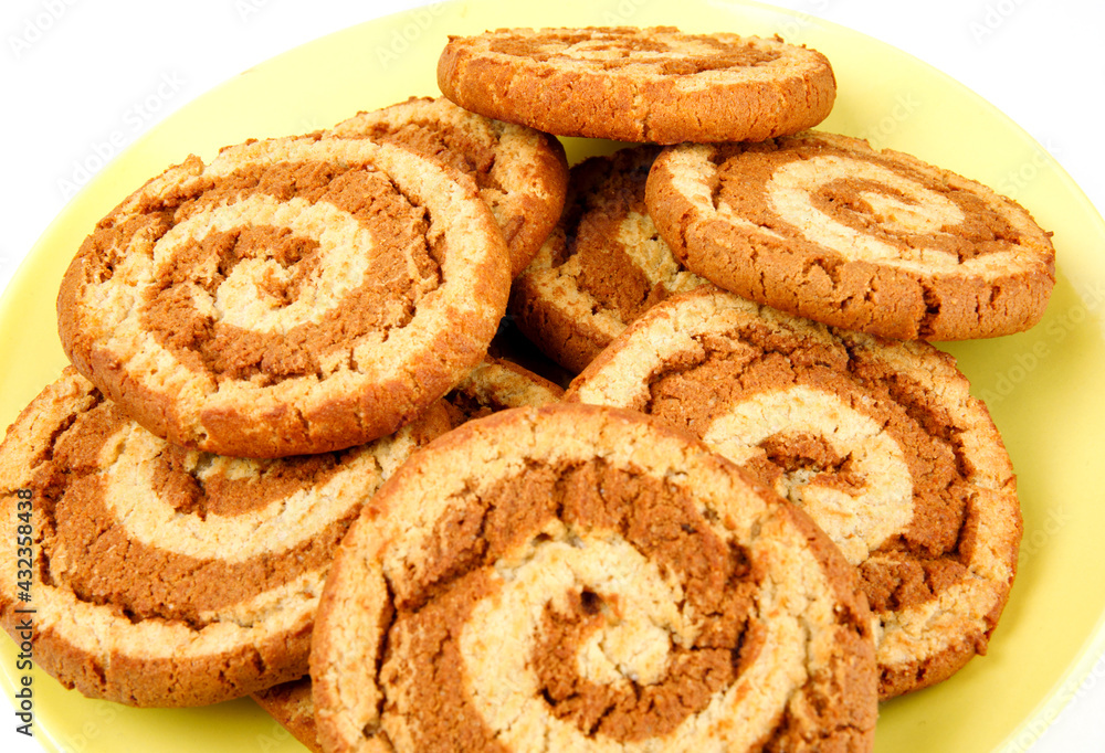 Beautiful cookies with a spiral pattern on a yellow plate. Beautiful cookies with a spiral pattern on a yellow plate.