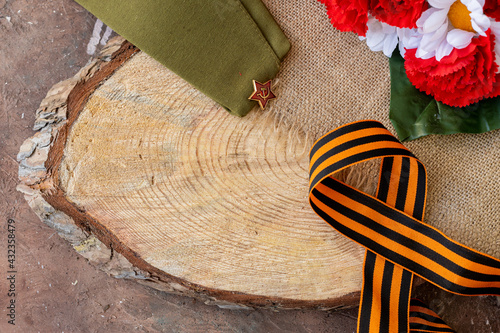 Concept background of May 9 russian holiday Victory Day. Red carnations, St. George's ribbon and order of the Red Star. On wooden background, copy space
